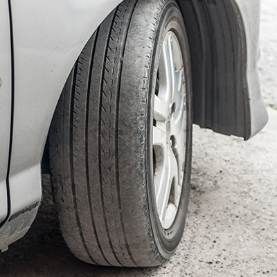 This tire is wearing unevenly, bald on the edge due to being driven with too little air inflation pressure